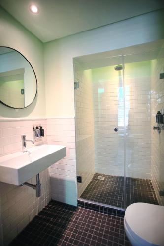 a bathroom with a shower and a sink and a toilet at The Grey Hotel in Cape Town