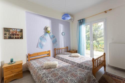 two twin beds in a bedroom with a window at Serene Villa in Kriopigi