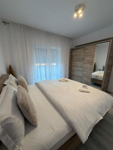 a large white bed in a bedroom with a large mirror at Natalia Apart in Alba Iulia