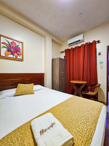 ein Hotelzimmer mit einem Bett und einem roten Vorhang in der Unterkunft Hostal Macambo in Iquitos