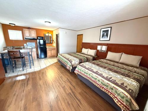 a hotel room with two beds and a kitchen at Hunter's Friend Resort near Table Rock Lake in Branson
