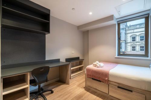 a bedroom with a desk and a bed and a window at Stylish & Spacious Studio - Prime Briggate Location -Walk Everywhere in Leeds