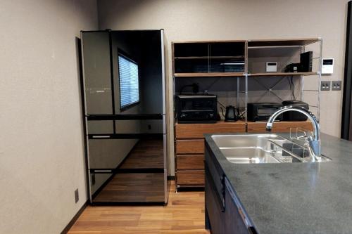 a kitchen with a sink and a refrigerator at 龍宿 Noboru Yado in Kagoshima