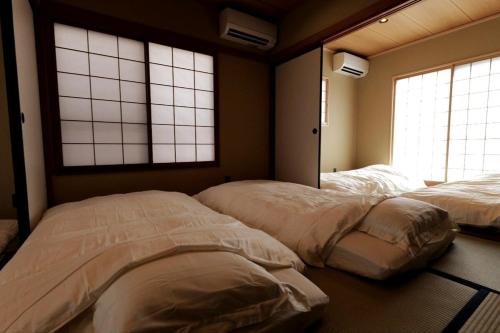 two beds in a room with two windows at 龍宿 Noboru Yado in Kagoshima