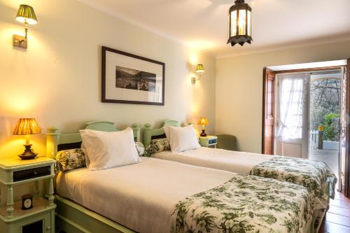 two beds in a room with two lamps at Casa da Azenha in Peso da Régua