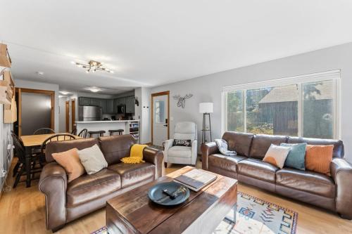 a living room with two leather couches and a table at 820 Badger Ln in Fraser