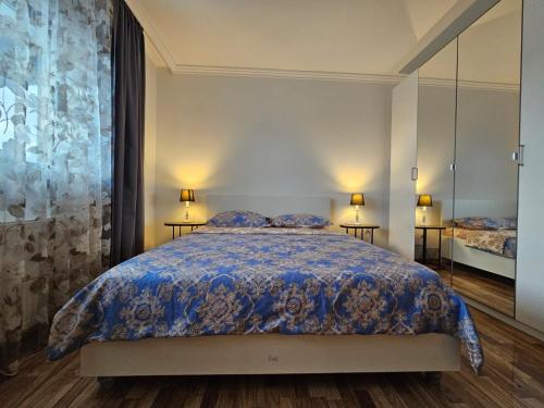 a bedroom with a bed with a blue comforter at Dante Residence in Alba Iulia
