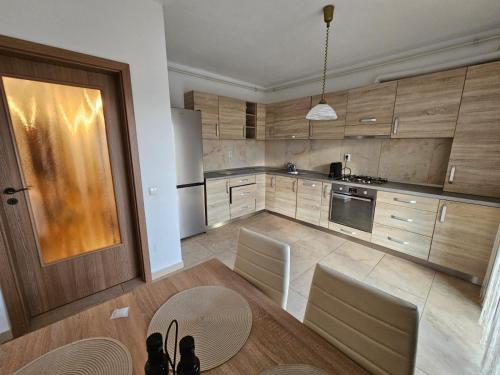 a kitchen with wooden cabinets and a table and chairs at Dante Residence in Alba Iulia