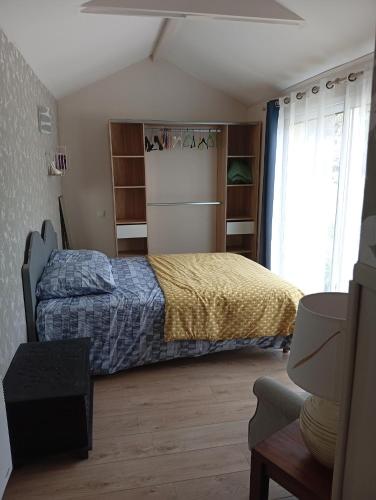 a bedroom with a bed and shelves and a window at Le studio des pins in Plouézec