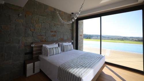 a bedroom with a bed and a stone wall at Sani Chateau in Sani Beach