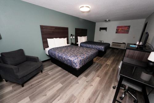 a hotel room with a bed and a chair at Scottish Inn Maggie Valley in Maggie Valley