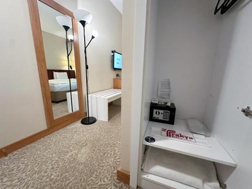 a room with a mirror and a room with a bed at Trakya City Hotel in Edirne