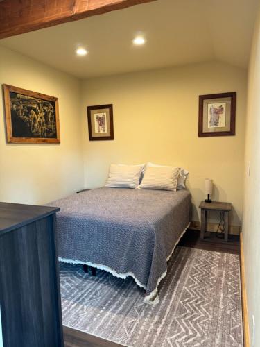 a bedroom with a bed and two pictures on the wall at Rustic Bay View Cabins- Lodge in Homer