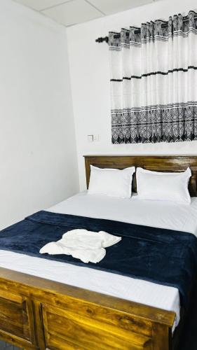a bedroom with a bed with a white robe on it at Livora Mountain Lodge in Etimole