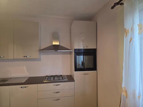 a small kitchen with a stove and a microwave at Villa Letina in Sukošan