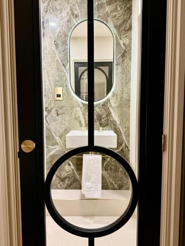 a bathroom with a round mirror and a sink at The Barkston in London
