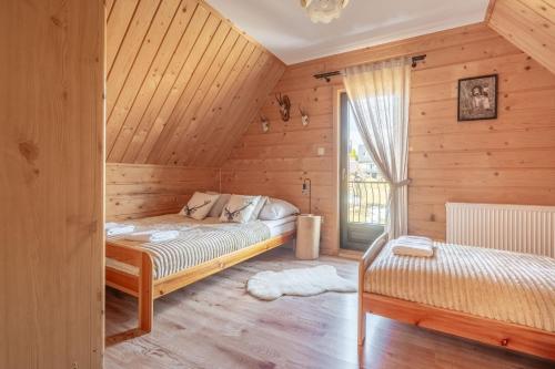 a bedroom with a bed in a wooden cabin at Domek Przy Potoku Murzasichle in Murzasichle
