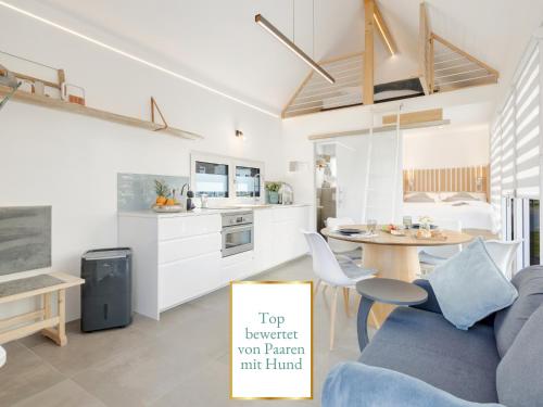 a kitchen and living room with a blue couch and a table at Stilvolles Design-Tiny-House mit Terrasse & Hund in Fuchsmühl