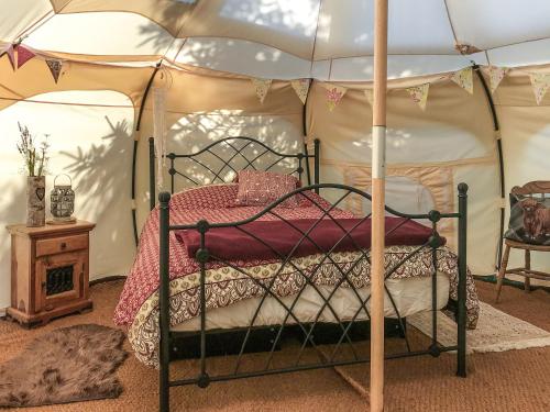 a bedroom with a canopy bed in a tent at Shepherds Belle & Croft Hut - Qu7633 in Messing