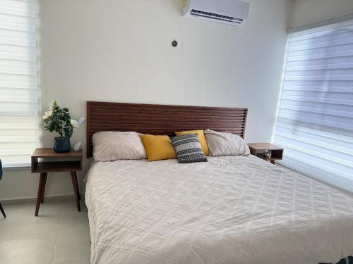 a bedroom with a large bed with yellow pillows at Casa completa , dos Habitaciones con baño en cada cuarto in Mérida