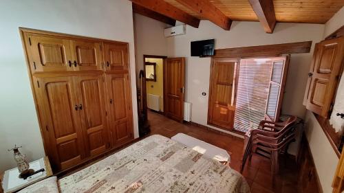 a bedroom with a bed and wooden cabinets and a chair at Casa rural con terraza en Cabanes - Mar y montaña - Ideal para grupos y familias in Cabanes