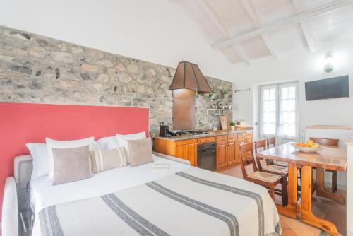 a bedroom with a large bed and a kitchen at Piccola Abbazia by RentAllComo in Lenno