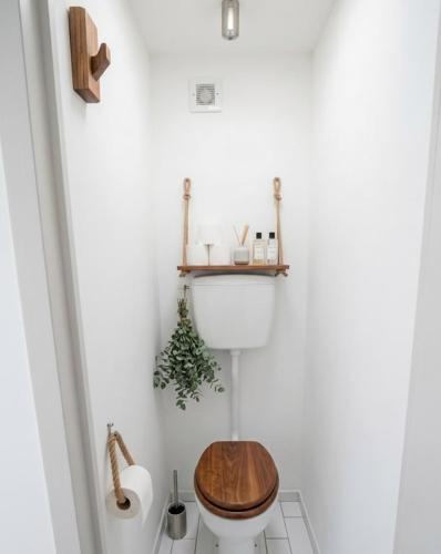 a bathroom with a toilet with a wooden seat at Vue sublime-conciergrie IB in Canet-en-Roussillon