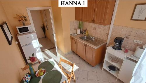 a small kitchen with a table and a microwave at Hanna Apartman 1-2 in Kőszeg