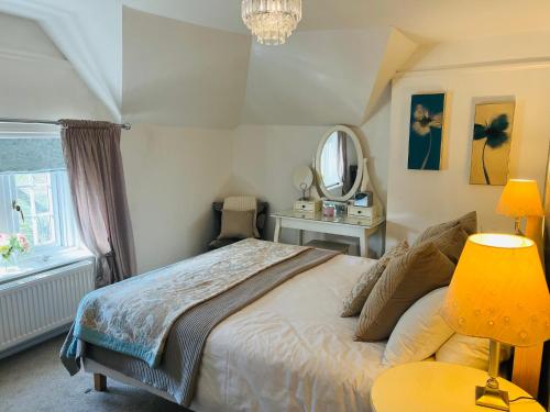 a bedroom with a large bed and a mirror at The Old Rectory Chicklade in Chicklade