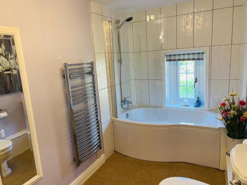 a bathroom with a tub and a toilet and a sink at The Old Rectory Chicklade in Chicklade