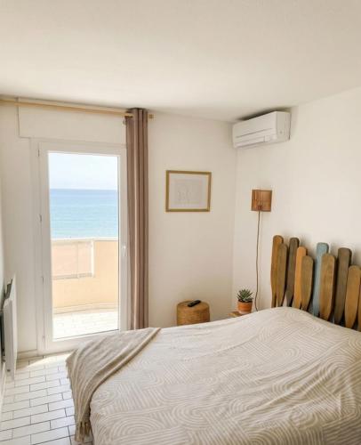 a bedroom with a bed and a view of the ocean at Vue sublime-conciergrie IB in Canet-en-Roussillon