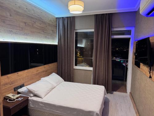 a small bedroom with a bed and a window at Temiz Hotel in Alanya