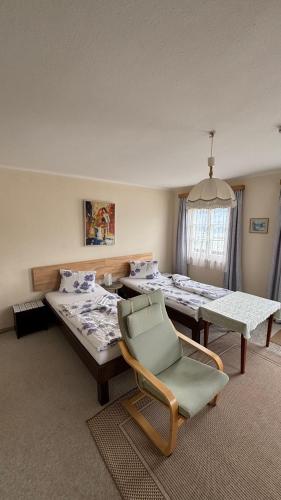 a room with two beds and a table and a chair at Ferienwohnung Haus Gomig in Dölsach