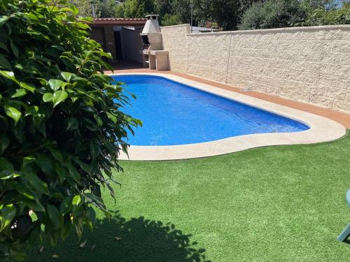 a swimming pool in a yard with green grass at Apartamento Río Bispo in Bueu