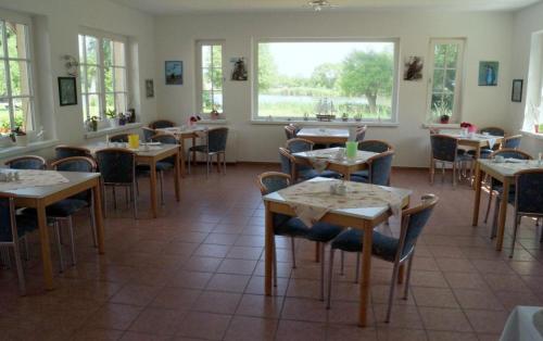 a restaurant with tables and chairs in a room at Dorotheenhof in Mescherin