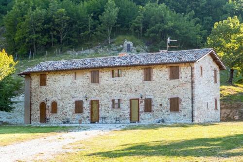 an old stone building with brown doors on a field at APPARTAMENTI Vista del Mondo in Spoleto