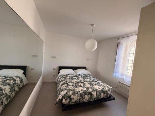 a bedroom with two beds and a window at Da Nella 2 in Ancona