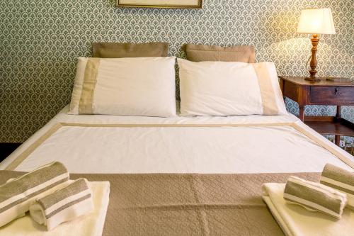 un letto con lenzuola e cuscini bianchi in una stanza di SUITE MARINELLA -TAORMINA a Taormina