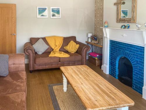 a living room with a couch and a fireplace at Tolcarne Retreat in Newquay