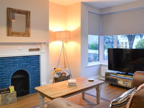 a living room with a tv and a fireplace at Tolcarne Retreat in Newquay