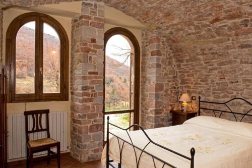 a bedroom with a bed in a stone wall at APPARTAMENTI Vista del Mondo in Spoleto
