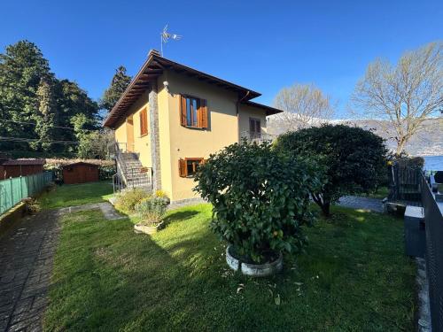 a small house with a tree in the yard at Villa Elvira fronte lago di Como by Gottschalk in Dervio