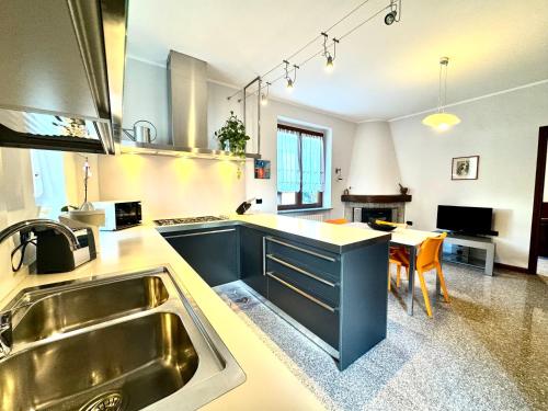 a large kitchen with a sink and a table at Villa Elvira fronte lago di Como by Gottschalk in Dervio