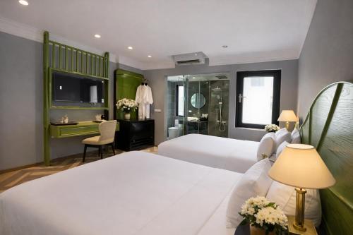 a hotel room with two beds and a television at Hanora Boutique Hotel in Hanoi