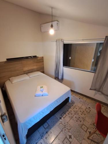 a bedroom with a bed with a towel on it at Kitnet Apart-Hotel 4 in Sete Lagoas