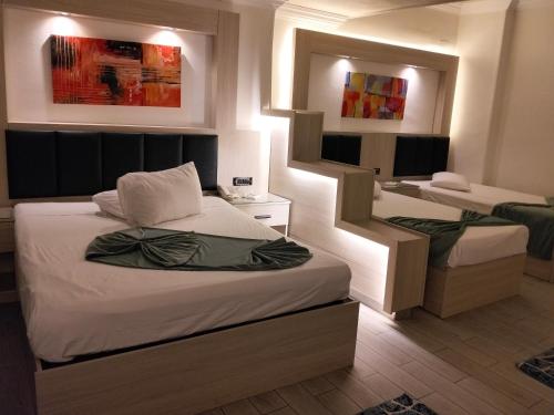 a bedroom with two beds and a desk in it at Havana Hotel Cairo in Cairo