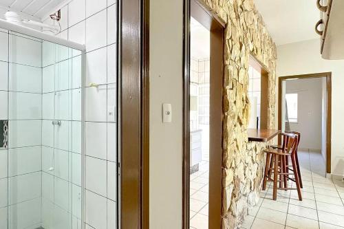 a bathroom with a walk in shower and a glass door at Residencial Zirke in Florianópolis