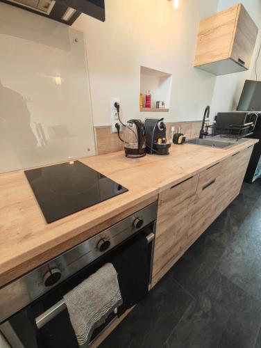 a kitchen with a wooden counter top with a sink at Le Box Circuit Magny-Cours in Saint-Parize-le-Châtel