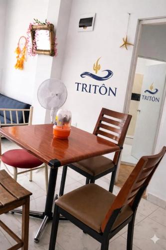 a table and chairs in front of a triton sign at Casa de Playa Triton in Máncora