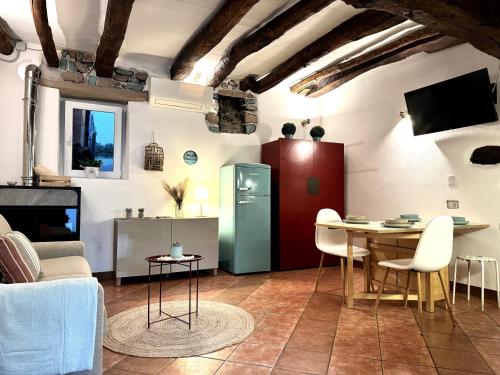 a living room with a table and a refrigerator at Casa Zita Cozy • AC near Lake Como by Gottschalk in Olgiasca